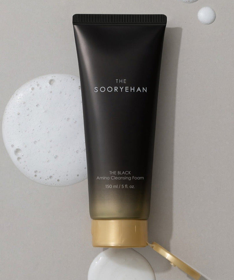 SOORYEHAN The Black Amino Cleansing Foam 150ml, tube noir sur fond clair avec mousse blanche, contexte beauté.