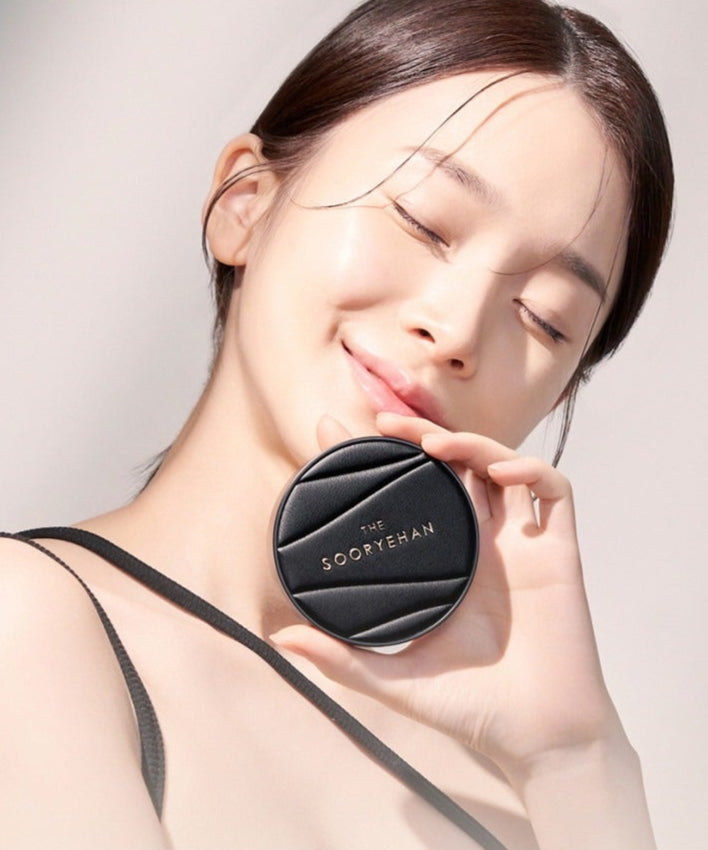 SOORYEHAN The Black Tension Fit Mesh Cushion 13g : femme lissant son visage, packaging noir sur la peau, fond clair.