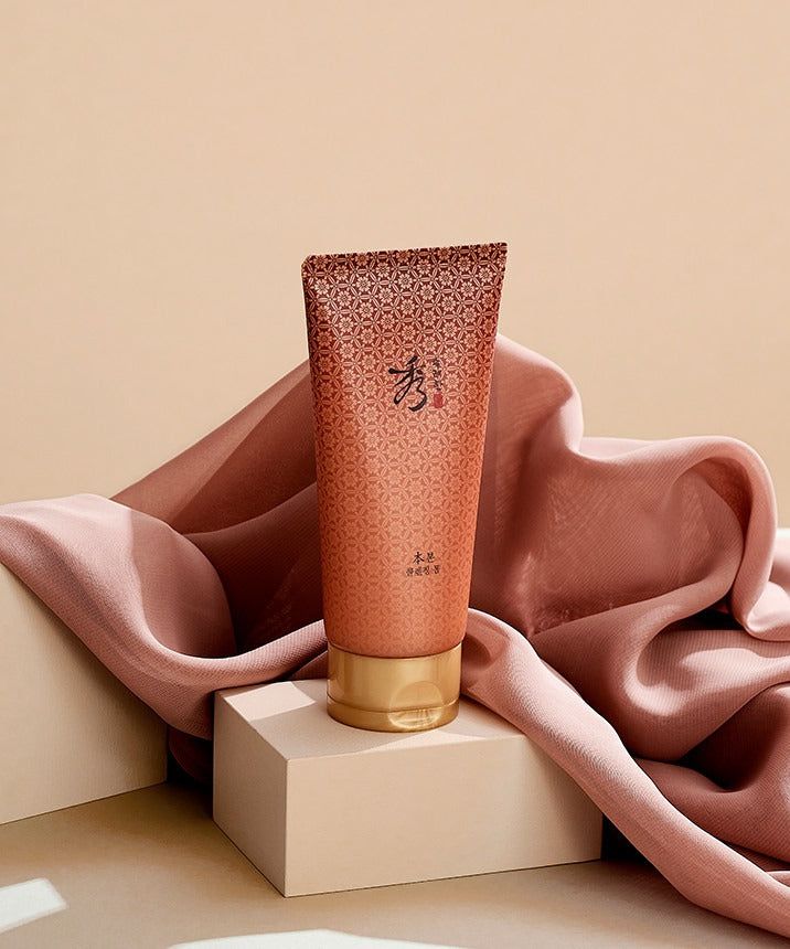 Crème nettoyante SOORYEHAN Bon Cleansing Foam 160ml élégamment posée sur un tissu rose, soin beauté luxueux et raffiné.