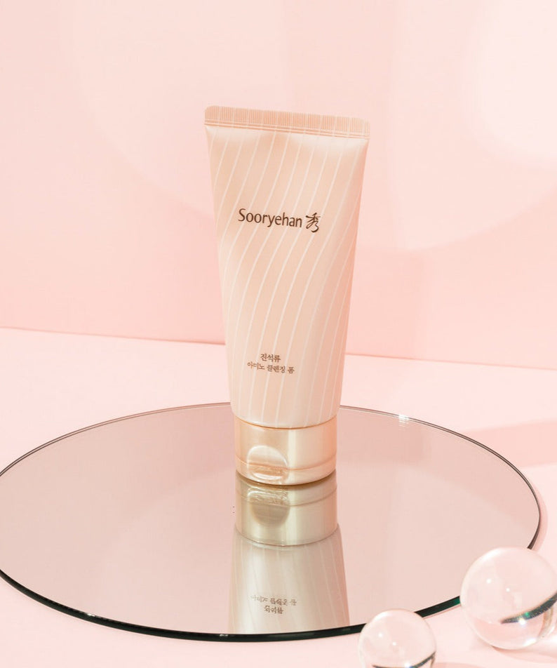 SOORYEHAN Jinseokryu Amino Cleansing Foam 160ml sur fond rose, reflet sur miroir.