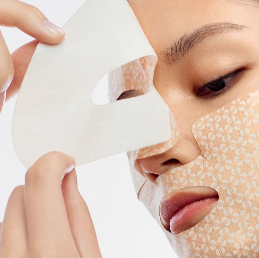 SULWHASOO Concentrated Ginseng Renewing Creamy Mask EX 5 sheets, masque en tissu sur le visage, mains appliquant la marque.