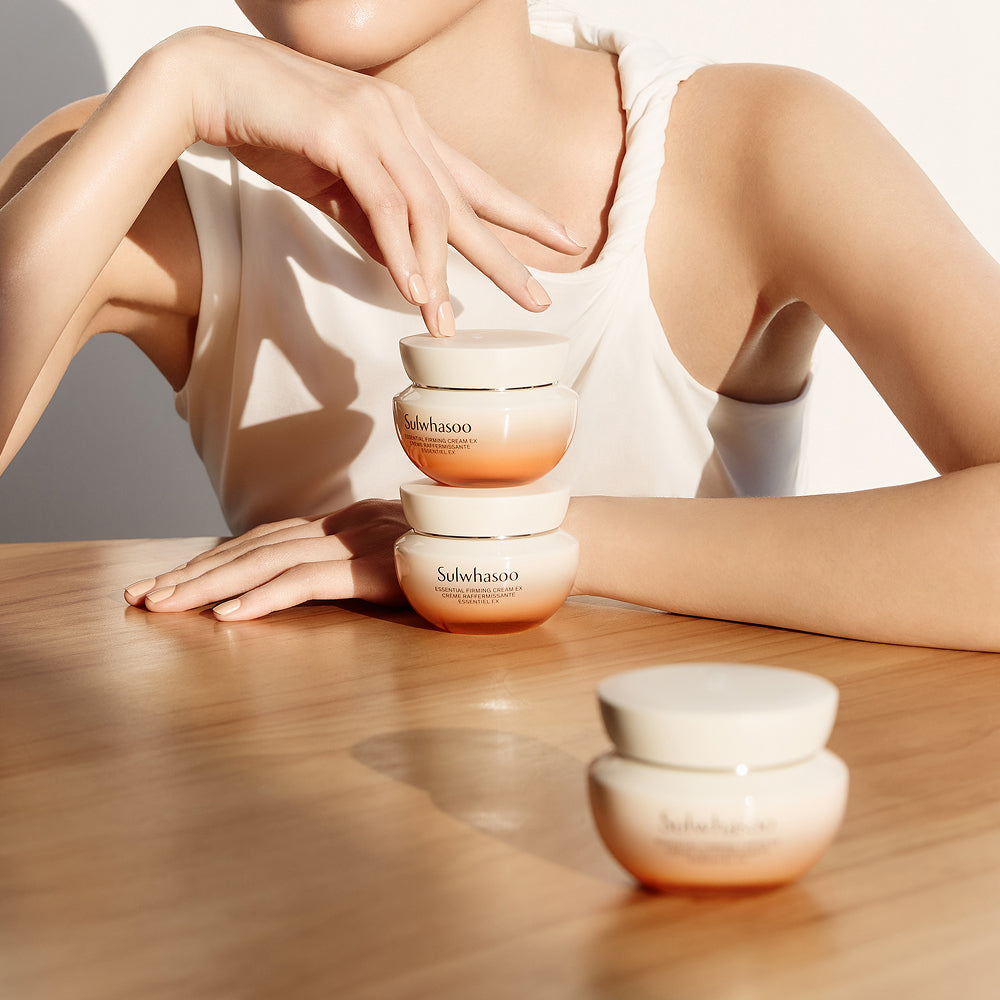 SULWHASOO Essential Comfort Firming Cream 75ml, crème anti-âge posée sur table, femme appliquant en institut, ambiance spa