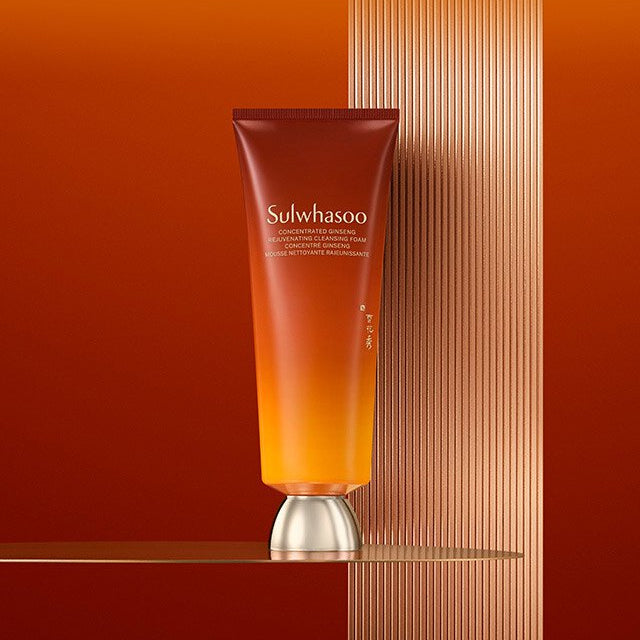 SULWHASOO Ginseng Rejuvenating Cleansing Foam 150g, tube sur fond orange avec lignes, ambiance spa luxe