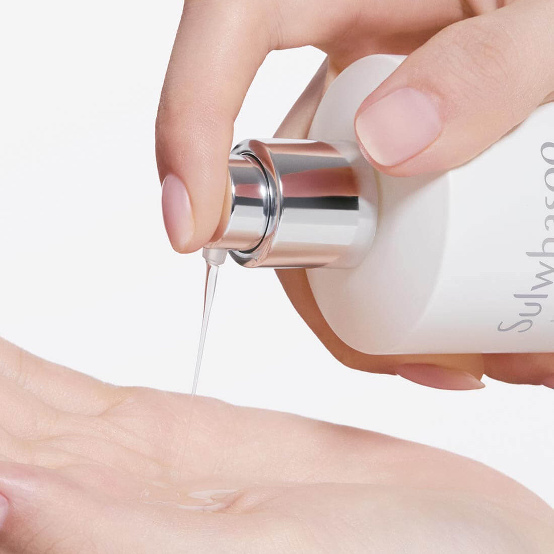 SULWHASOO Lumiwise Brightening Essence Water 150ml : application du sérum éclaircissant, flacon et mains, fond clair.