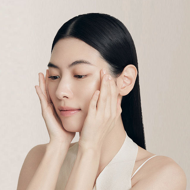 Décris l'image en français : SULWHASOO Yunjo Essence 6th Generation 120ML(Year of the Horse Edition) posé dans un soin visage.