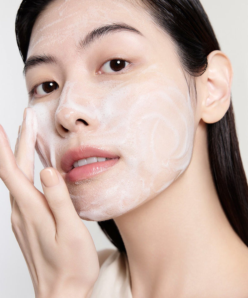 Femme appliquant SULWHASOO Ginseng Rejuvenating Cleansing Foam 150g sur son visage pour un soin de la peau rajeunissant.