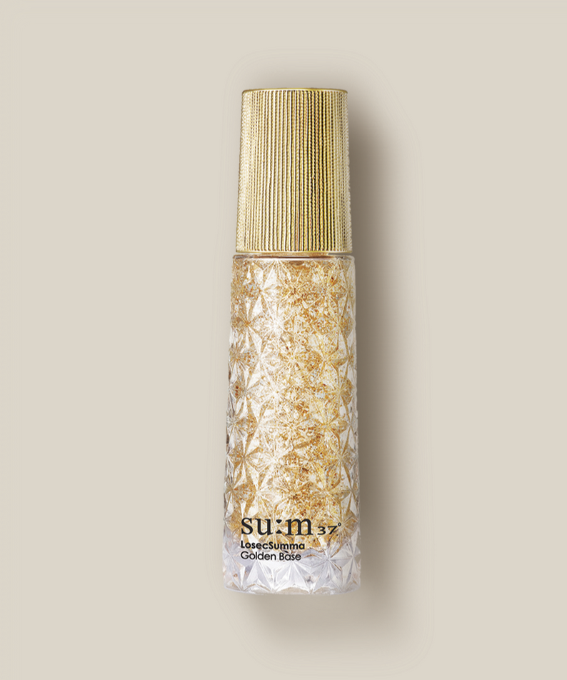 SU:M37 LosecSumma Golden Base 30ml sur fond beige, flacon doré SU:M37, style cosmétique premium.