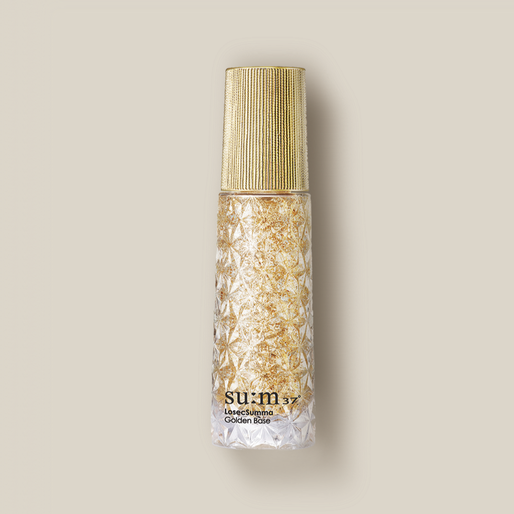 SU:M37 LosecSumma Golden Base 30ml sur fond beige, flacon doré SU:M37, style cosmétique premium.