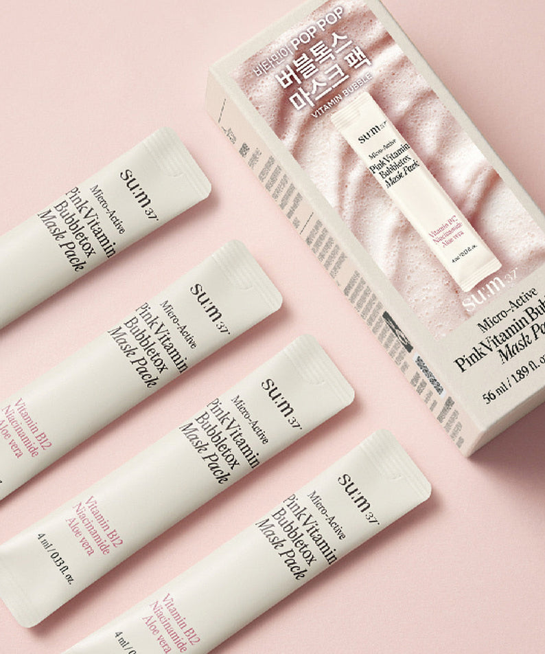 Boîte et sachets de SU:M37 Microactive Pink Vitamin Bubble Tox Mask 4ml (14 sheet ) sur fond rose.