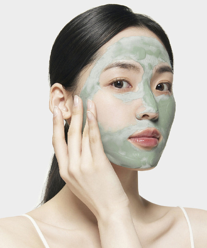 Femme appliquant le SU:M37 Microactive Super Matcha Pore Mask 100ml pour des pores purifiés et une peau éclatante.
