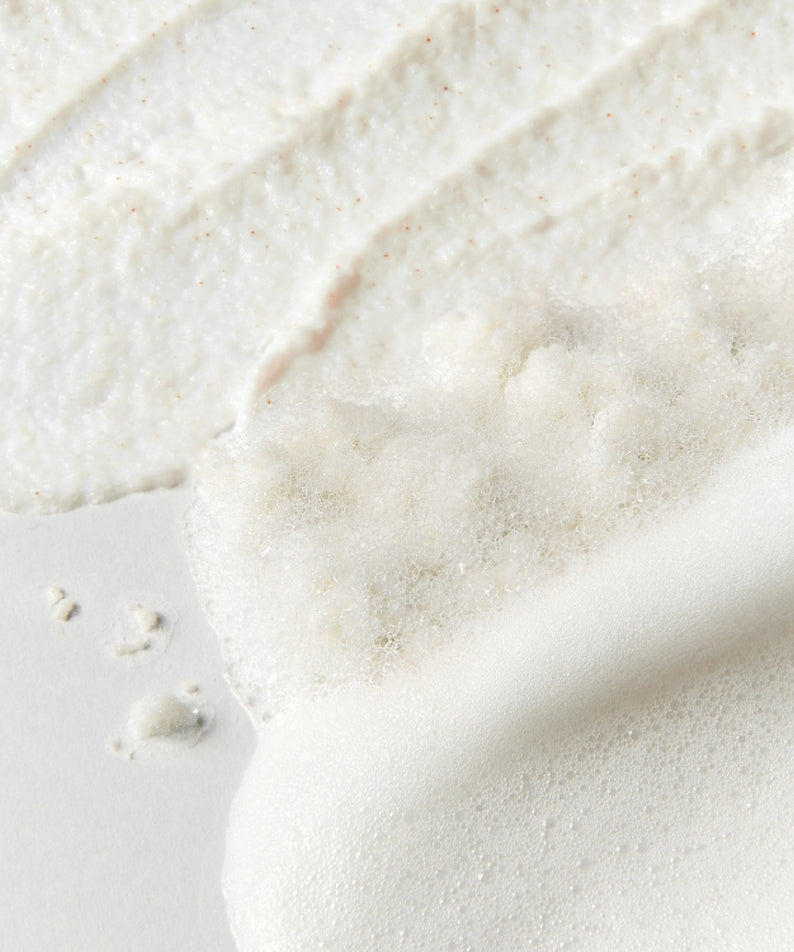 Texture du SU:M37 Secret Rice Nuruk Peeling to Foam Cleanser 120g sur fond blanc, montrant sa mousse et ses grains exfoliants.