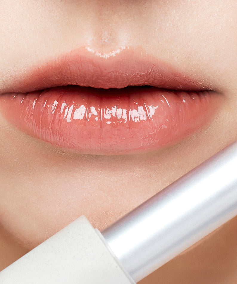 BAUME À LÈVRES SU:M37 Skin-Stay Glossy appliqué sur lèvres brillantes et pulpeuses. Rouge à lèvres en gros plan.