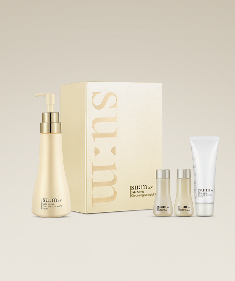 Ensemble SU:M37 Skinsaver Essential Cleansing Foam sur fond beige, comprenant plusieurs produits de soins pour la peau.
