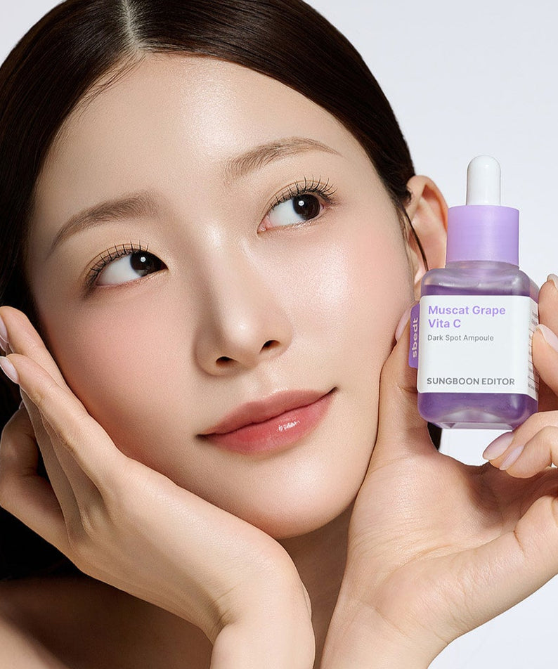 SUNGBOON EDITOR Grape Vita C Dark Spot Whitening Ampoule 40ml, femme en gros plan tenant le sérum violet.