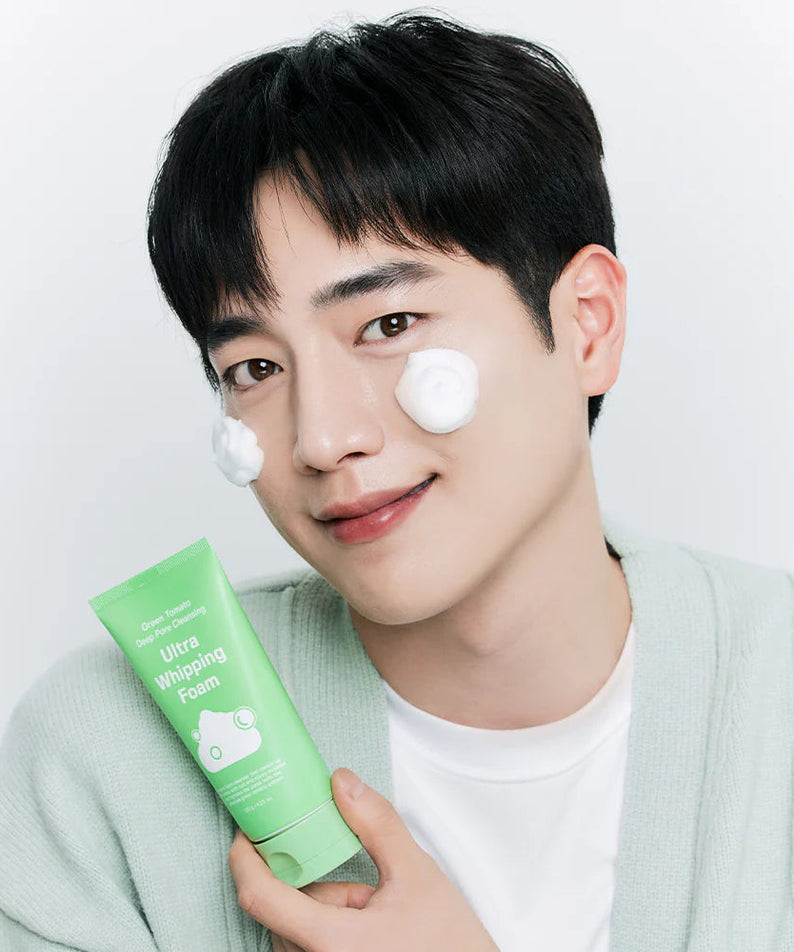 SUNGBOON EDITOR Green Tomato Pore Whipping Foam 120g, tube vert brandi par un homme sur fond clair, mousse visible