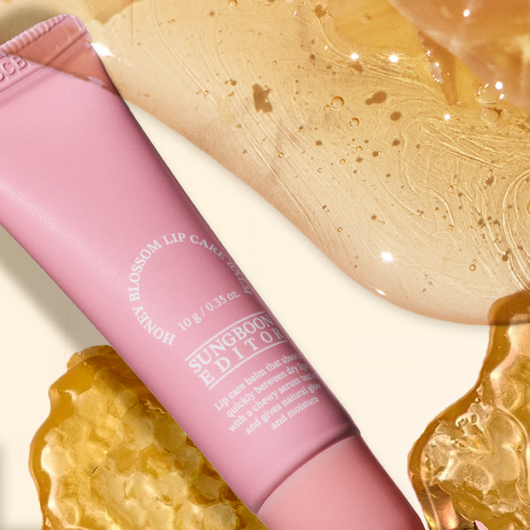SUNGBOON EDITOR Honey Blossom Lip Care Balm, tube rose avec texture miel, gros plan sur fond doré et paillettes.