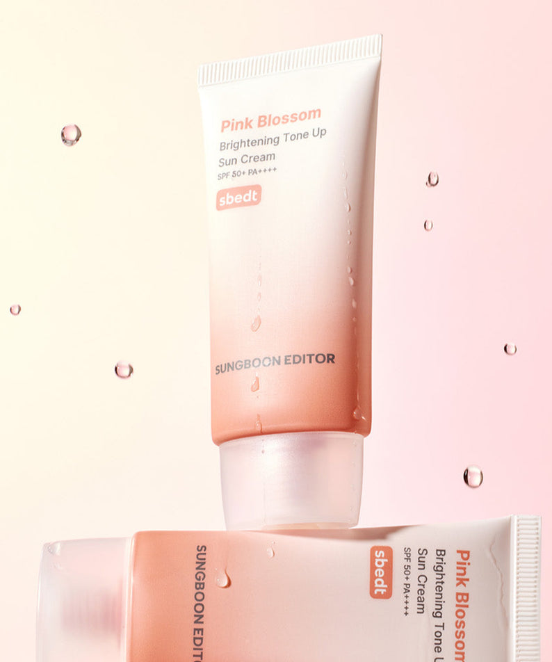 SUNGBOON EDITOR Pink Blossom Brightening Tone-Up Sunscream 50ml, crème solaire rose sur fond rose pastel, gouttes d'eau