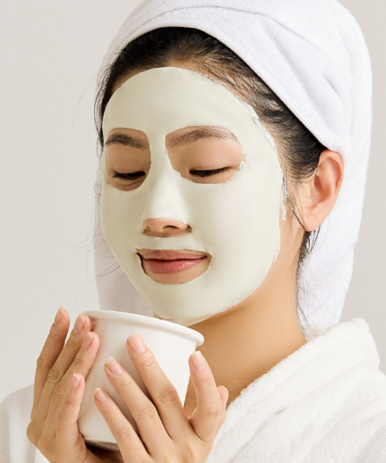 Femme appliquant SUNGBOON EDITOR Boosting Modeling Pack Green Tomato Pore Tightening pour resserrer les pores et hydrater la peau.