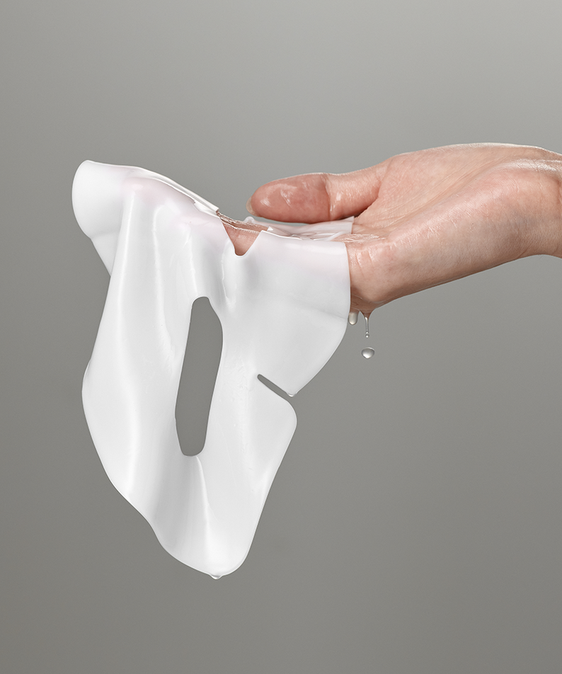 Main tenant un masque hydratant SUNGBOON EDITOR Deep Collagen Hyalu-B5 avec de la main, montrant son aspect lisse et humide.