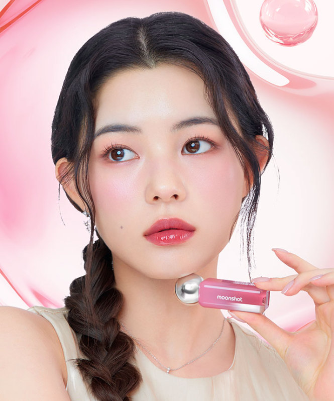 MOONSHOT Jelly Moon Glow Tint dans une teinte rose tenue par une femme, arrière-plan texturé en rose lustré.