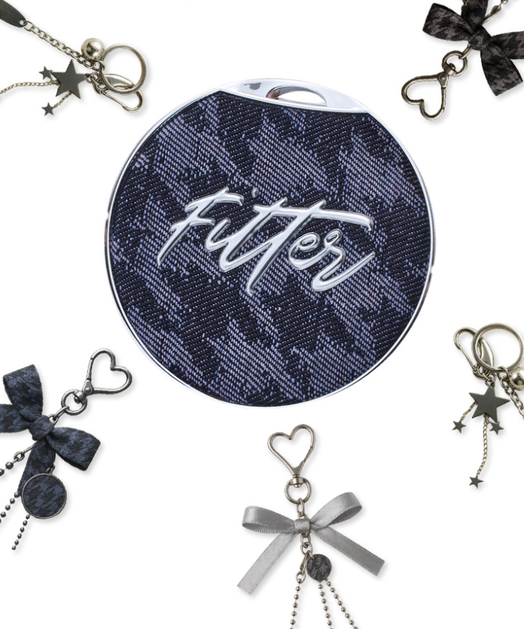 Clés décoratives autour d'une trousse design avec motif "Fitter". Accessoires élégants incluant coeurs et étoiles. Décor moderne.