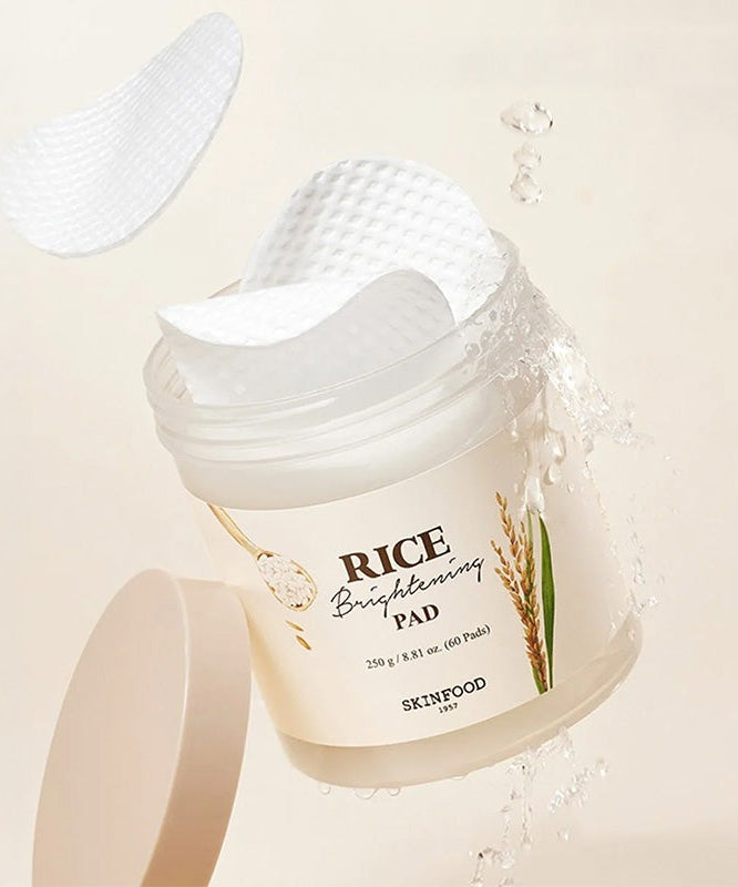 SKINFOOD Rice Brightening Pad 60p 250g de la marque SKINFOOD, pads blancs et éclaboussures d’eau sur fond clair