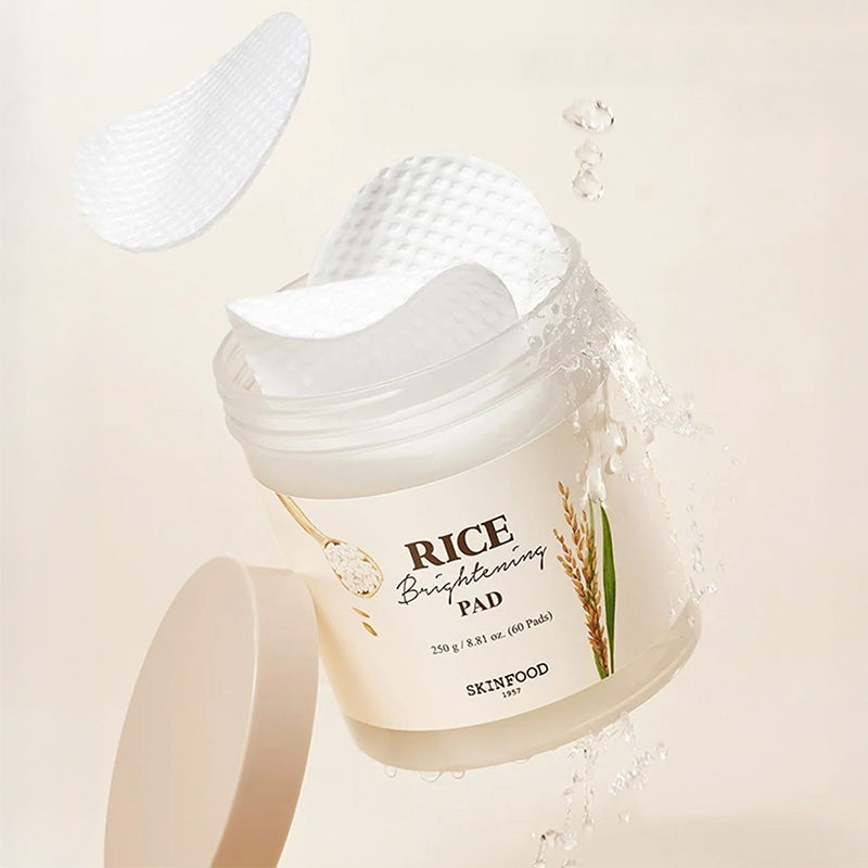 SKINFOOD Rice Brightening Pad 60p 250g de la marque SKINFOOD, pads blancs et éclaboussures d’eau sur fond clair