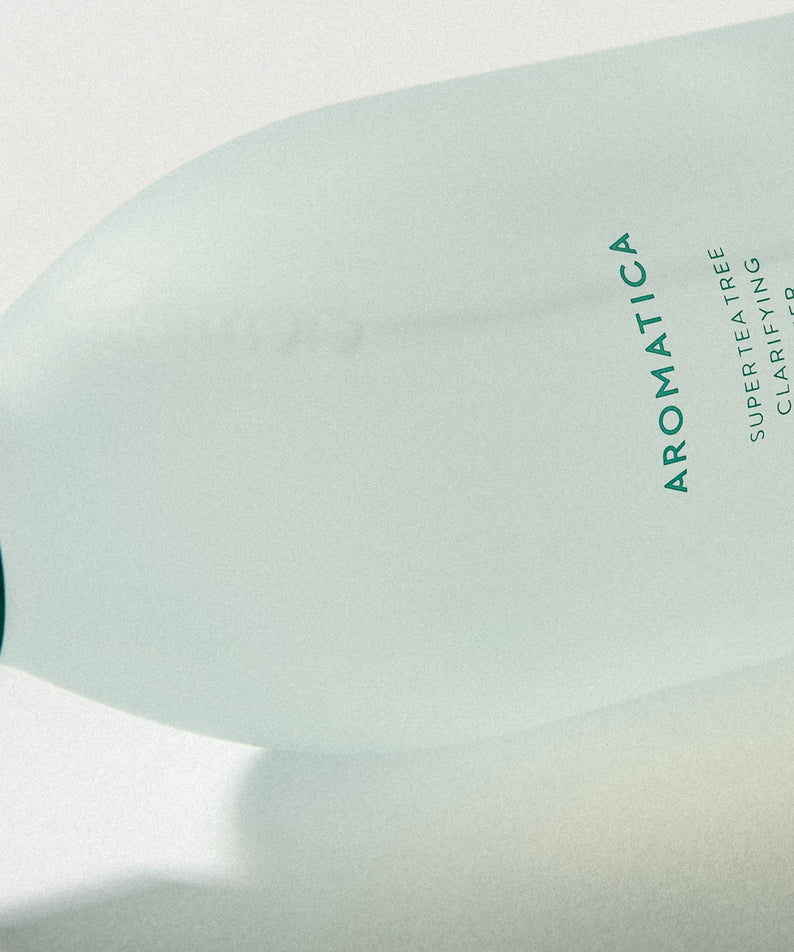 Bouteille de AROMATICA Super Tea Tree Clarifying Toner 200ML posée de côté pour une meilleure vue du design épuré.
