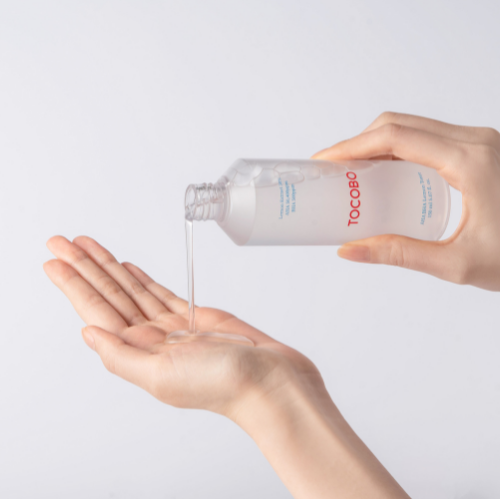 TOCOBO AHA BHA Lemon Toner : mains versant le toner sur la peau, flacon blanc sur fond clair, marque TOCOBO