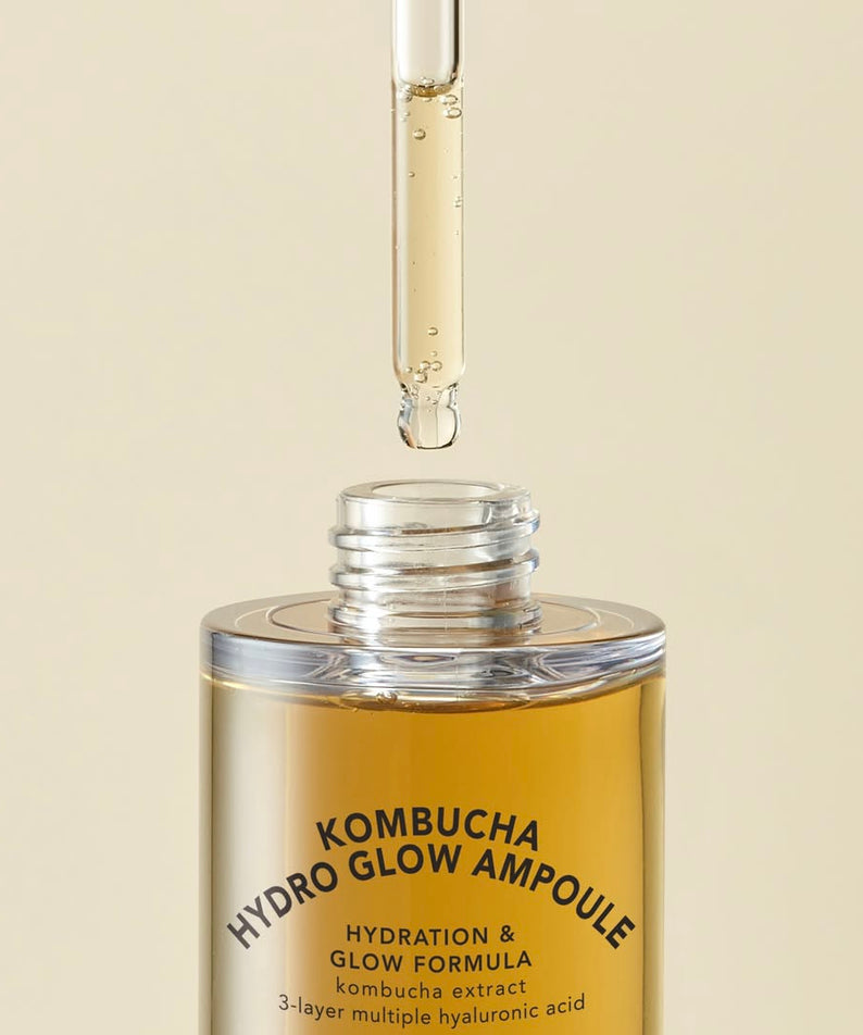Image of T'ELSE Kombucha Hydro Glow Ampoule 30ml en train d'être appliquée avec une pipette, montrant la formule hydratante luxueuse.