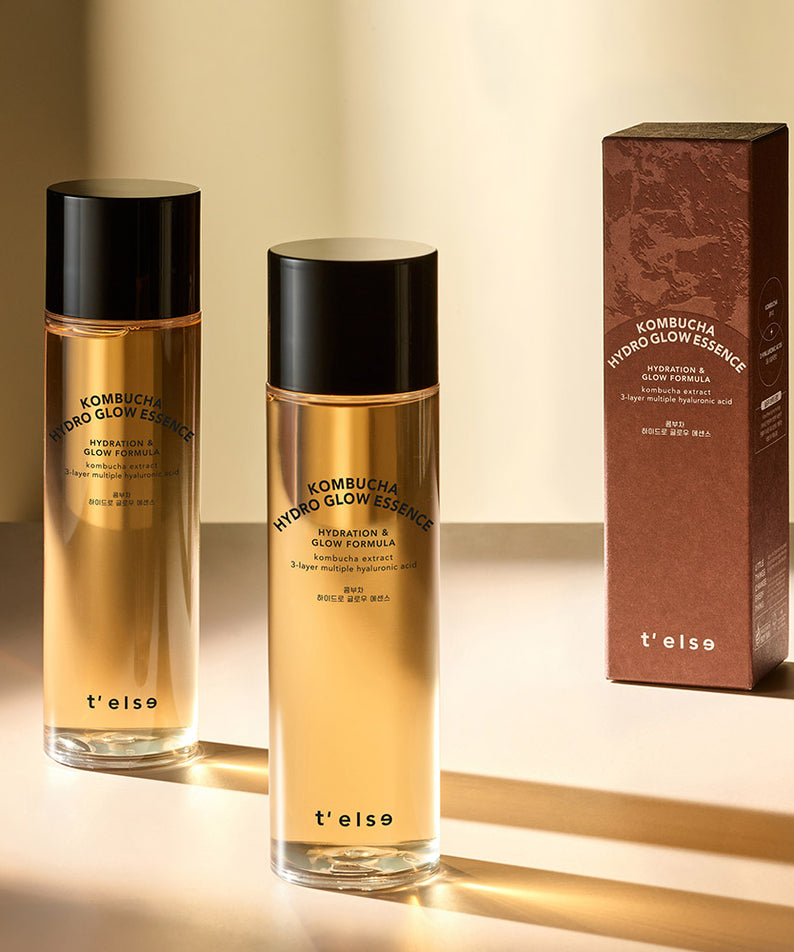 Deux bouteilles de T'ELSE Kombucha Hydro Glow Essence 150ml avec boîte, paraît lumineux et hydratant sur une table.
