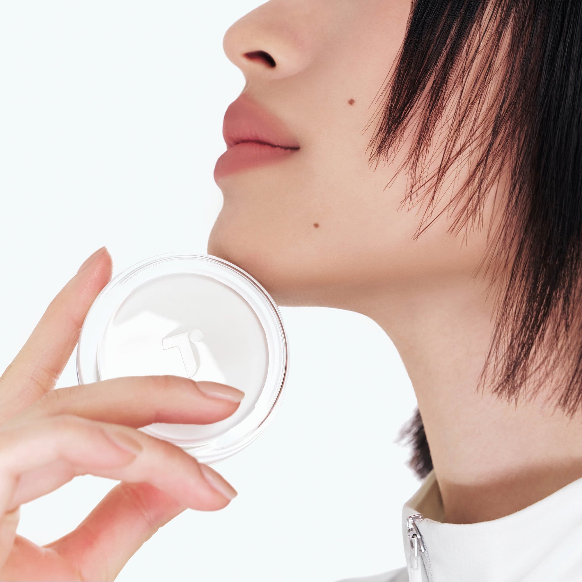 Décris l'image en français: TENSE Hybrid Makeup Saver de la marque TENSE, visage de femme tenant un pot, fond clair.