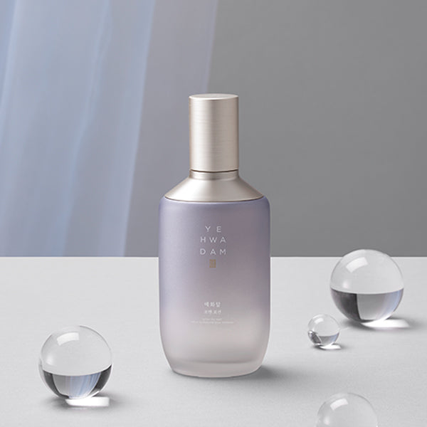 Décris l'image en français : THE FACE SHOP  Yehwadam For Men Lotion 150ml, flacon blanc sur fond gris avec éléments sphériques