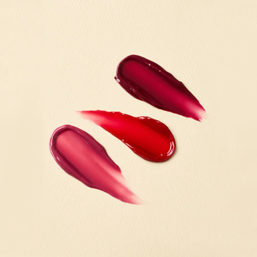 THE SAEM Saemmul Candy Syrup Gloss, marque coréenne, maquillage brillant rouge sur fond crème, gros plan texture
