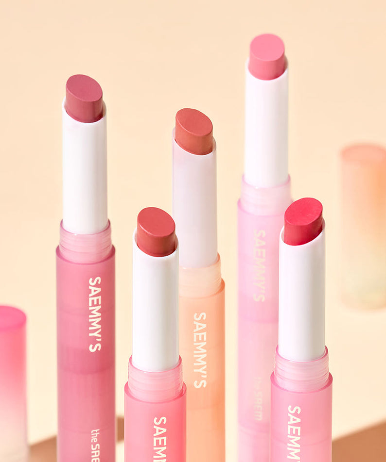 THE SAEM Saemmy's Crema Velvet Lipstick de la marque THE SAEM, sur fond beige, tubes et baumes roses.