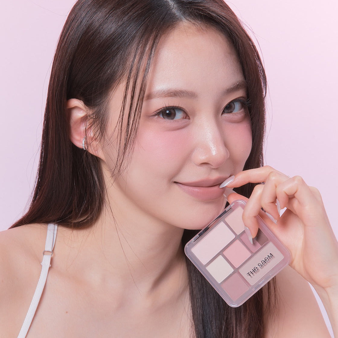 Portrait maquillage avec THE SEAM Shadow Box Palette, marque THE SEAM, palette ombres dans un décor rose pastel.
