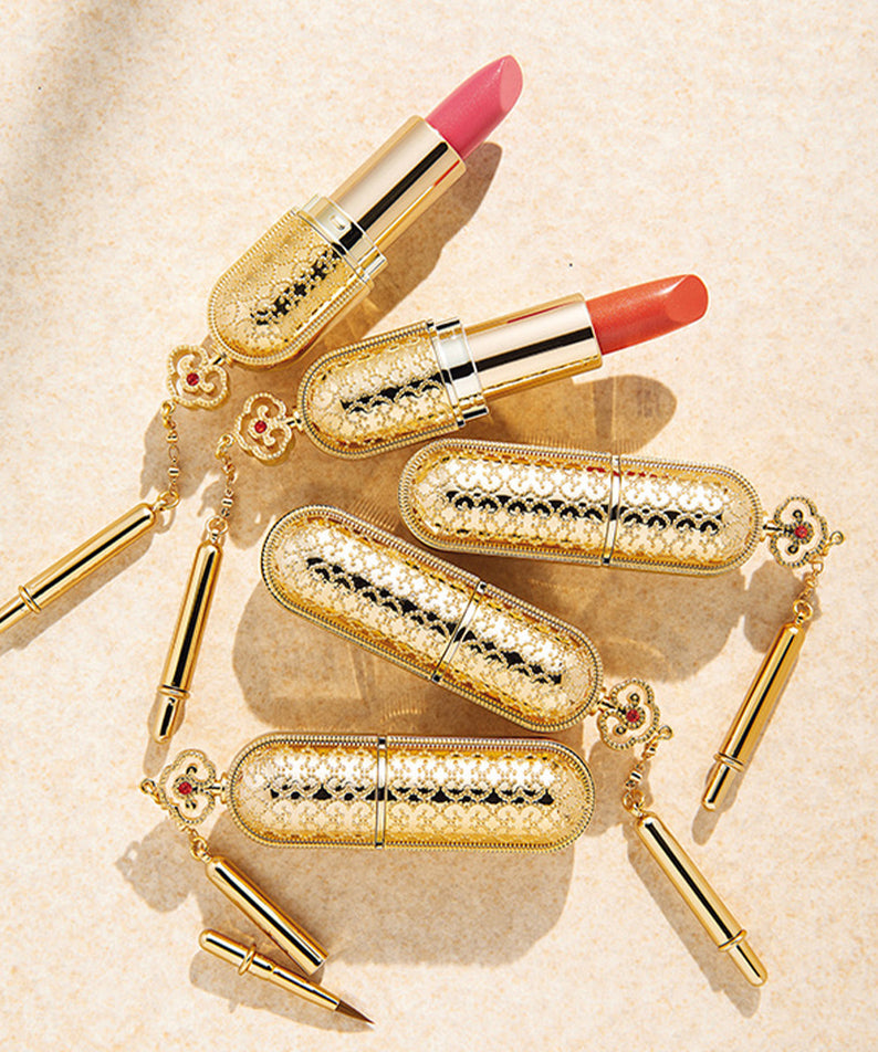 Rouges à lèvres de luxe dorés THE WHOO Gong Jin Hyang Mi Luxury Lipstick exposés sur un fond beige élégant.