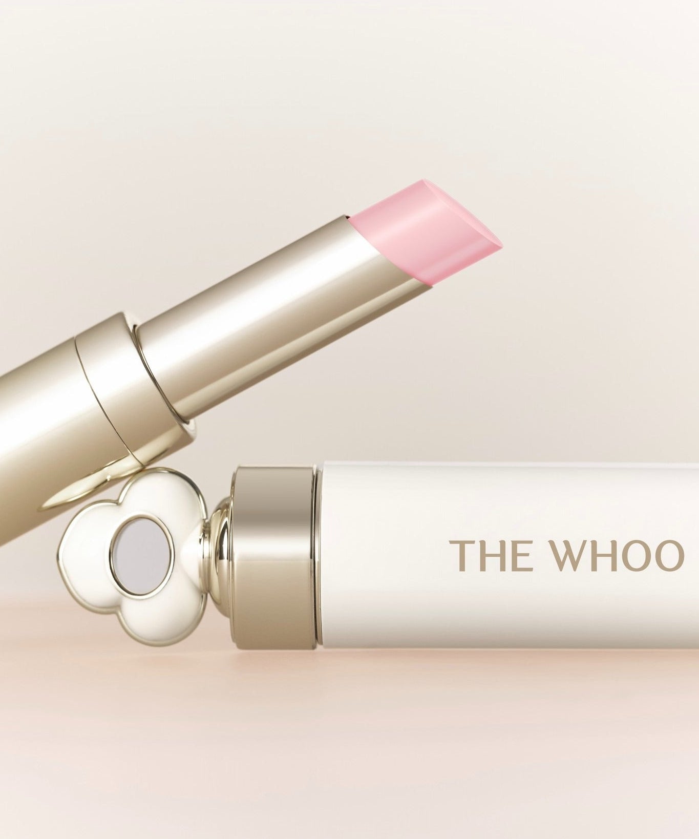 Baume à lèvres THE WHOO Essentail Lip Glow Balm avec emballage élégant et moderne en arrière-plan.