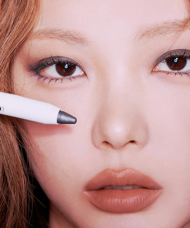 Produit TIP TOE Glide Shadow Stick appliqué sur les yeux d'une femme pour un look maquillage sophistiqué.