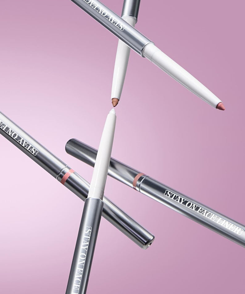 Quatre TIP TOE Stay On Face Liner stylos sur fond rose, maquillage professionnel pour précision et tenue longue durée.