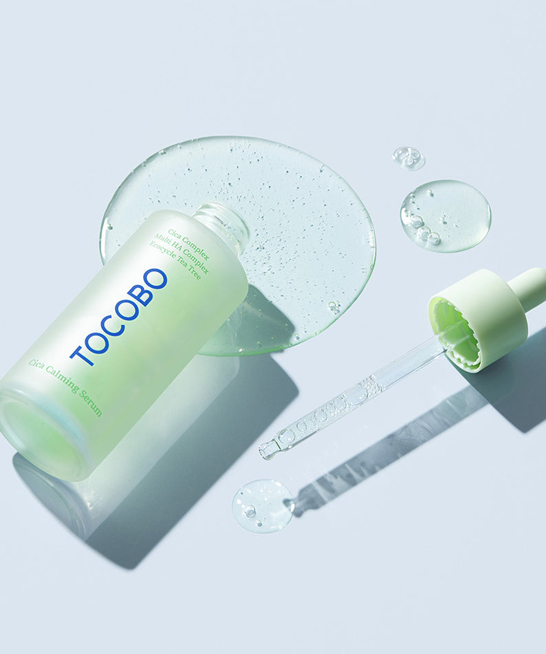 Sérum apaisant TOCOBO Cica présenté avec une pipette sur fond bleu. Solution idéale pour calmer la peau sensible.