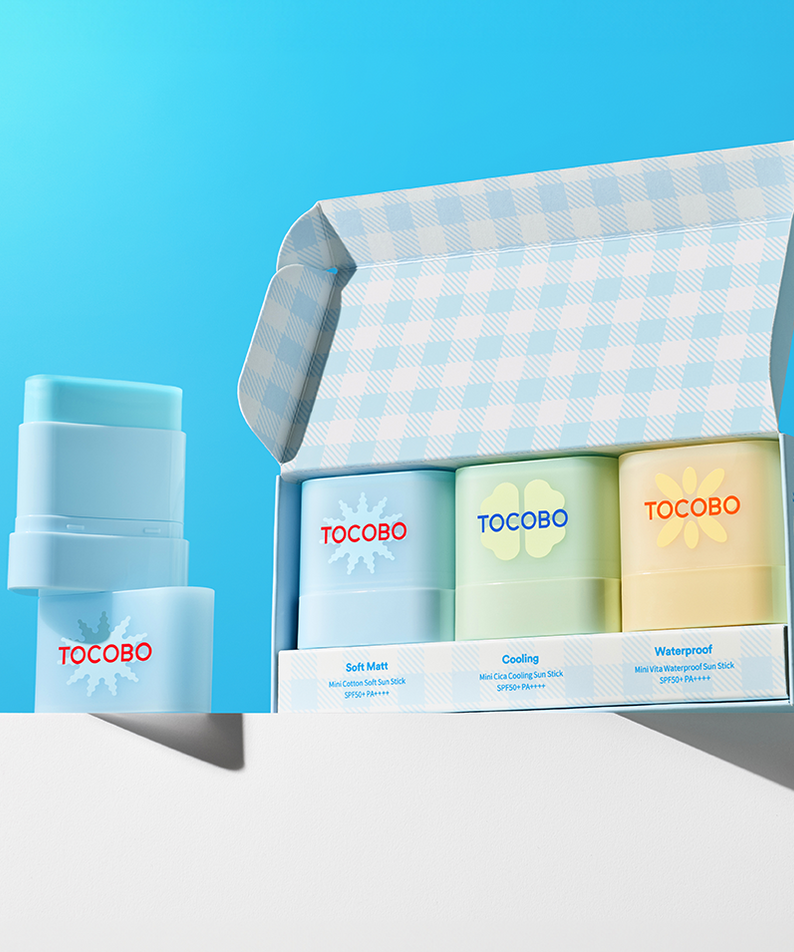 TOCOBO Mini Sun Stick Trio, produits TOCOBO sur fond bleu, pack et sticks à côté pour le maquillage et la protection solaire