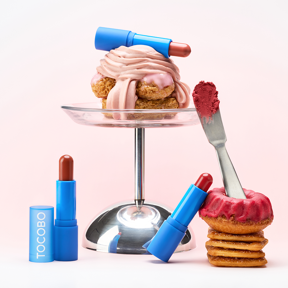 TOCOBO Powder Cream Lip Balm, tube bleu et crème sur dessert rose sur fond clair, style beauté pâtisserie