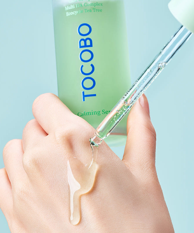 TOCOBO Cica Calming Serum : sérum apaisant TOCOBO sur une main, texture goutte, fond bleu clair