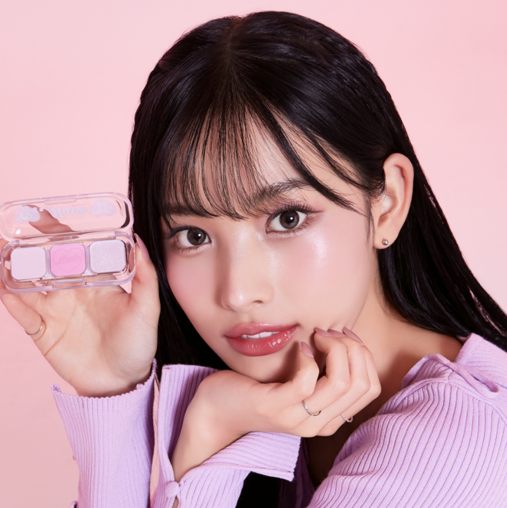 TONY MOLY Eyetone Eyeshadow Palette, femme maquillée tenant la palette, teintes pastel sur fond rose. Marque TONY MOLY.