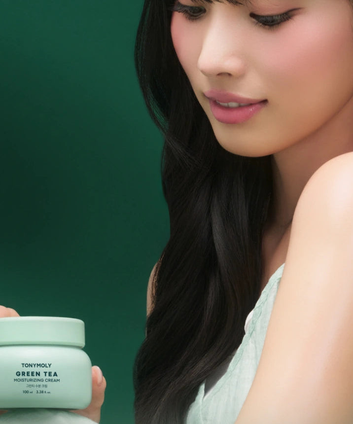 Décris l'image en français : TONY MOLY Green Tea Moisture Cream 60ml, pot vert, femme, arrière-plan vert.