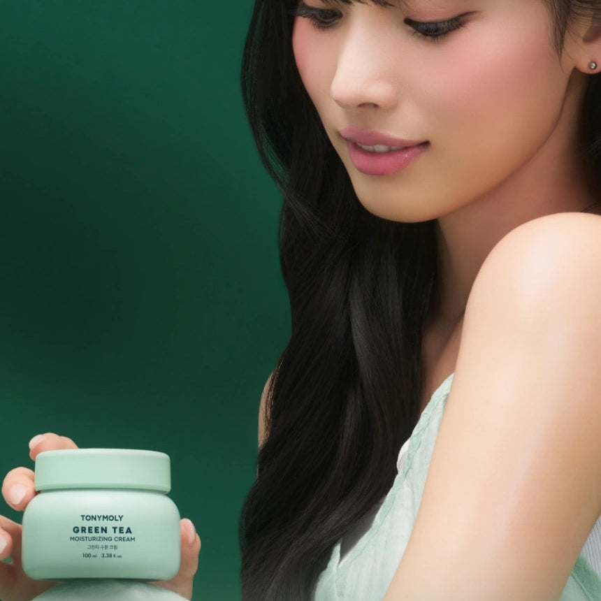 Décris l'image en français : TONY MOLY Green Tea Moisture Cream 60ml, pot vert, femme, arrière-plan vert.