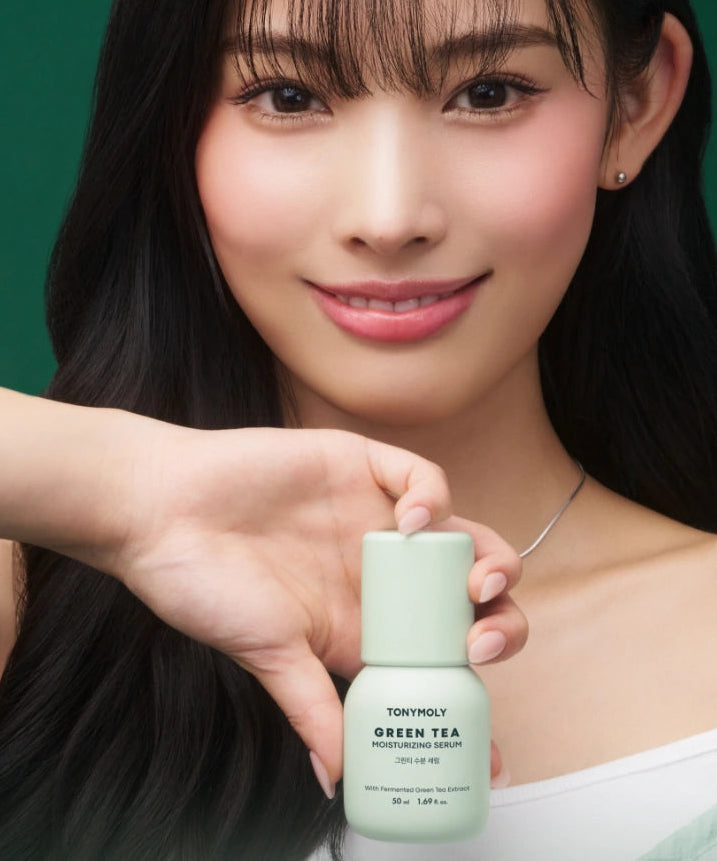 TONY MOLY Green Tea Moisture Serum 50ml, TONY MOLY: sérum photo produit tenu par une femme, fond vert.