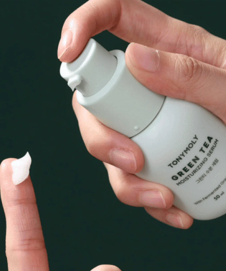 Main tenant TONY MOLY Green Tea Moisture Serum 50ml, flacon vert menthe sur fond sombre, sérum hydratant marque TONY MOLY