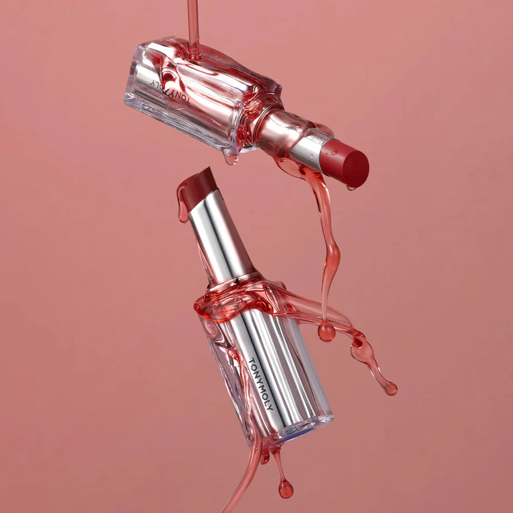 TONY MOLY Get It Tint Syrup Stick : stick à lèvres rose, gouttes de texture, sur fond rose, gros plan.